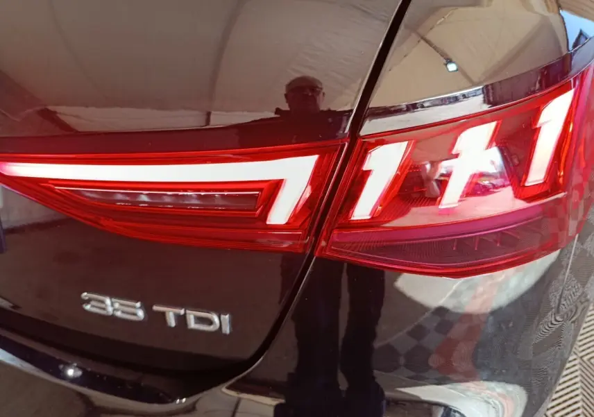Gros plan sur le feu arrière droit et le logo 35 TDI d'une Audi A3 noire, version diesel.