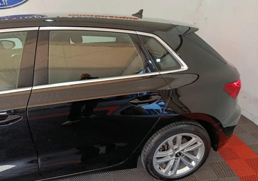Vue latérale arrière droite d'une Audi A3 noire 2023 avec jantes alliage et feux arrière LED visibles.