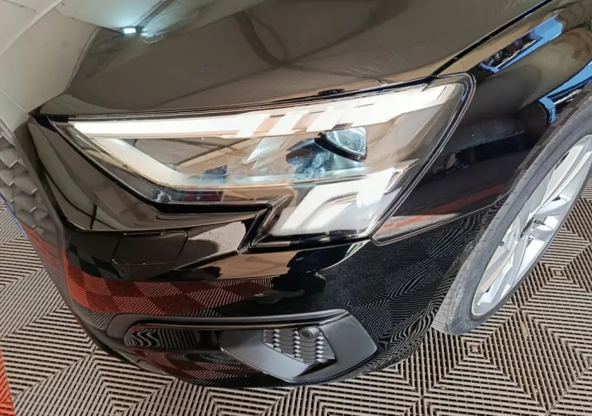 Gros plan sur l'avant droit noir de l'Audi A3 35 TDI 150 S tronic avec phares LED et calandre distinctive.