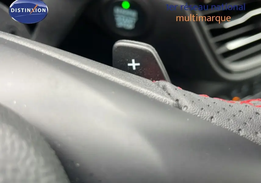 Détail du levier de commande au volant avec surpiqûres rouges dans l'habitacle du Ford Kuga 2024 bleu Vapor Metal.