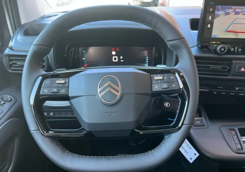 Vue rapprochée du volant cuir multifonctions du Citroën Berlingo 2025 avec écran tactile affichant la caméra de recul.