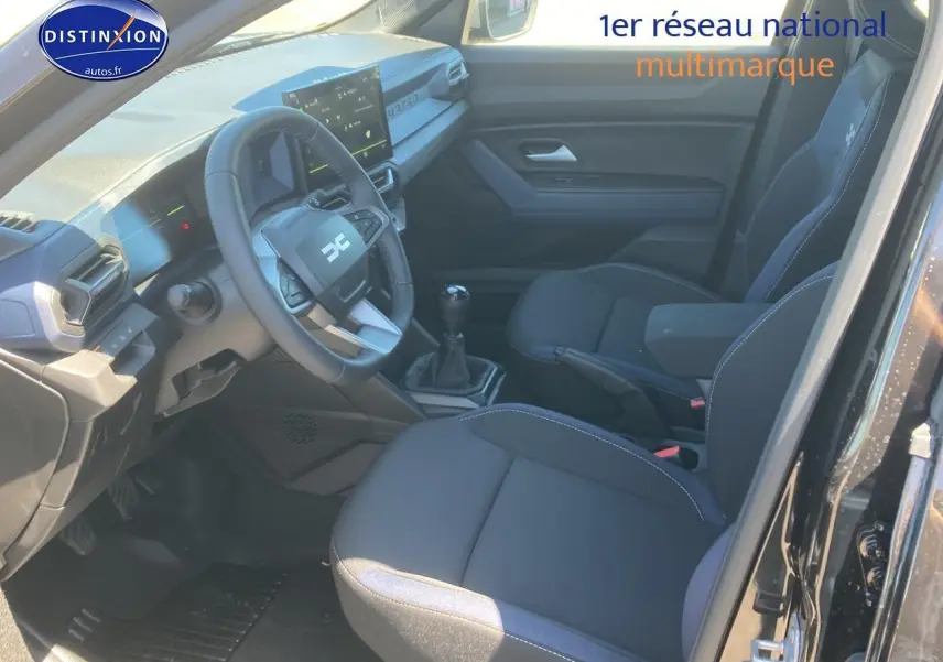 Intérieur noir du Dacia Duster 2025, vue côté conducteur avec volant multifonction et boîte manuelle.