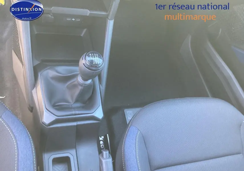 Gros plan sur la boîte manuelle et siège avant droit tissu gris du Dacia Duster noir 2025, intérieur fonctionnel.