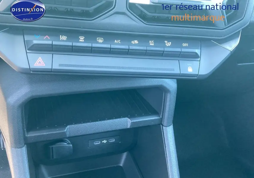 Vue rapprochée de la console centrale noire du Dacia Duster 2025 avec commandes climatisation et ports USB visibles.