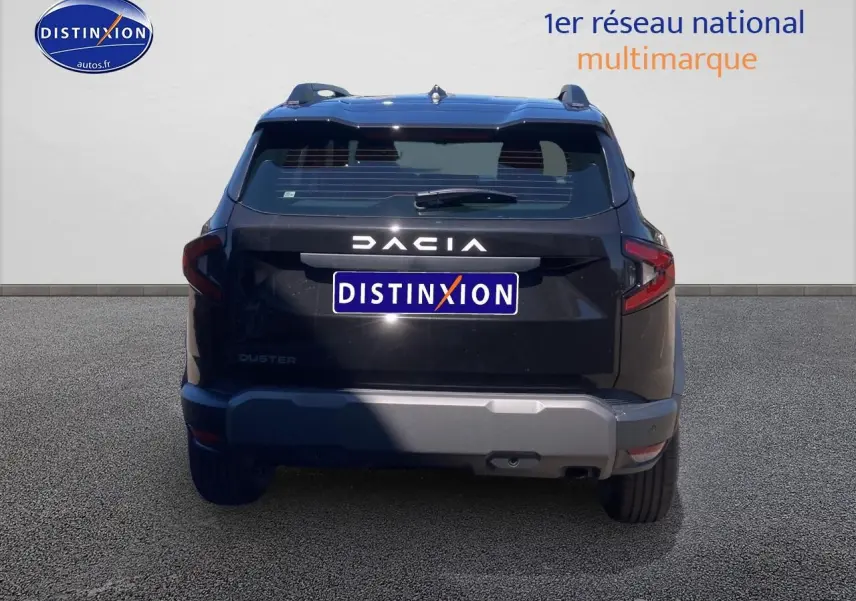 Vue arrière du Dacia Duster noir 2025 avec barres de toit et logo DACIA bien visible.