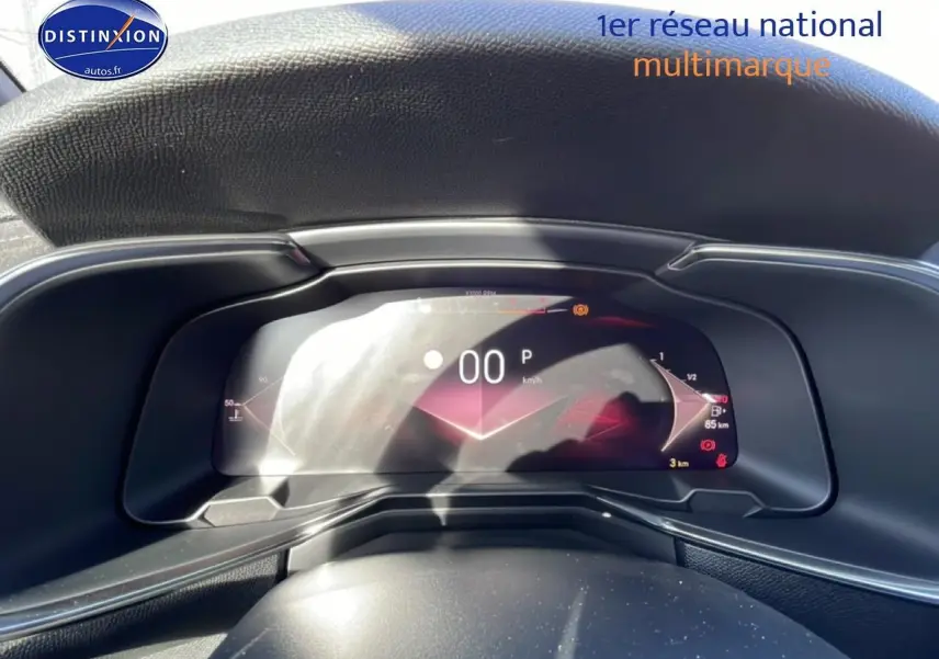 Vue rapprochée du tableau de bord numérique du DS7 bleu, affichant la vitesse à 0 km/h et l'indicateur de carburant.