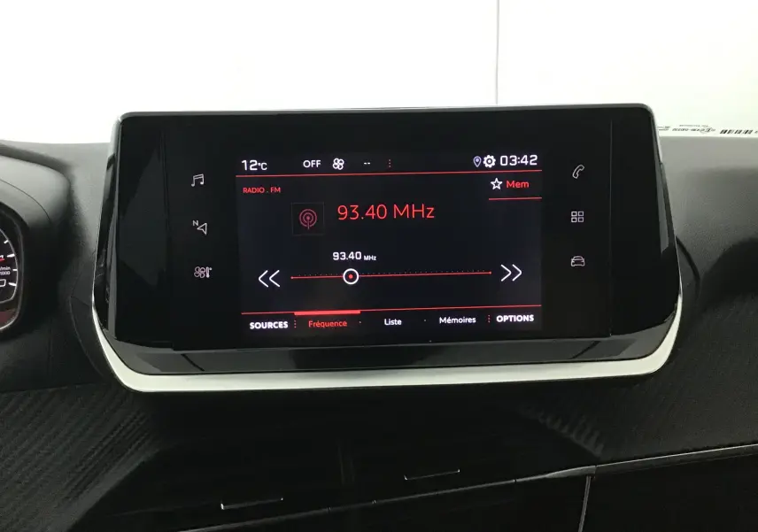 Écran tactile central de la Peugeot 208 noire 2022 affichant la radio FM à 93,40 MHz dans l'habitacle.
