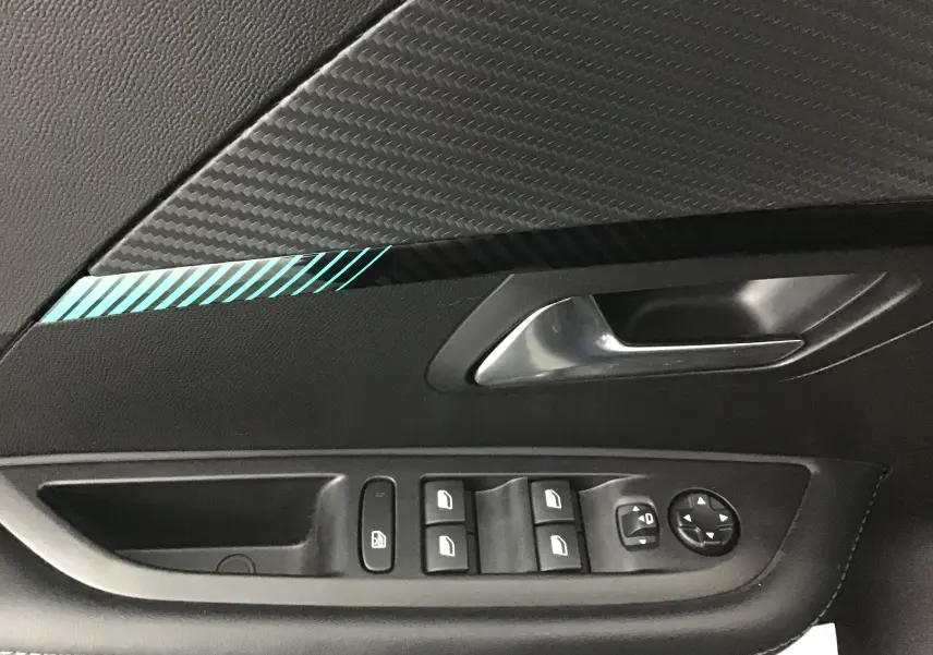 Détail de la porte intérieure côté conducteur d'une Peugeot 208 noire avec commandes de vitres et poignée argentée.