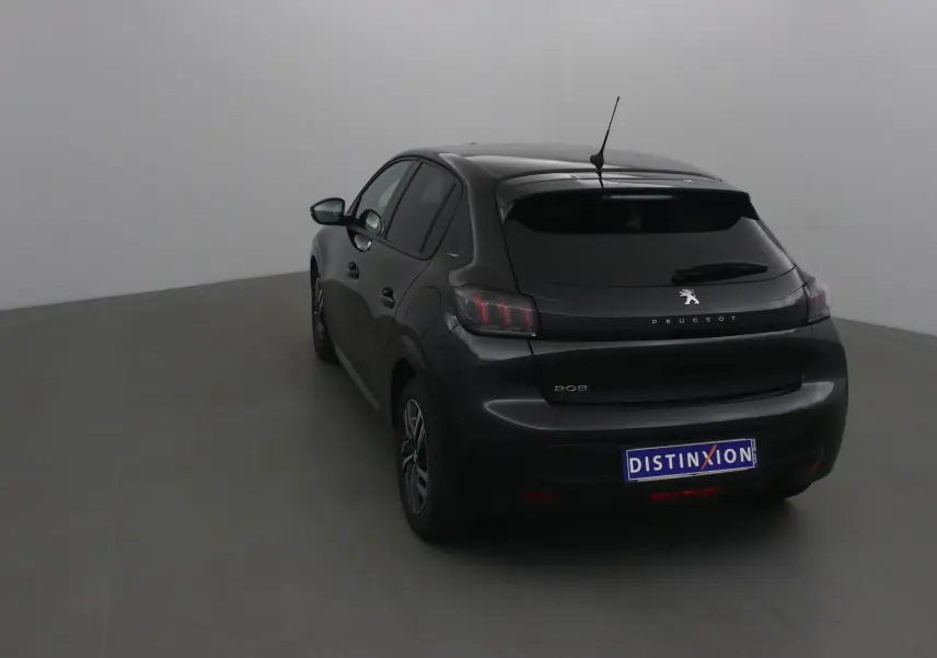 Vue 3/4 arrière gauche d'une Peugeot 208 noire 2022 avec feux arrière caractéristiques et antenne sur le toit.