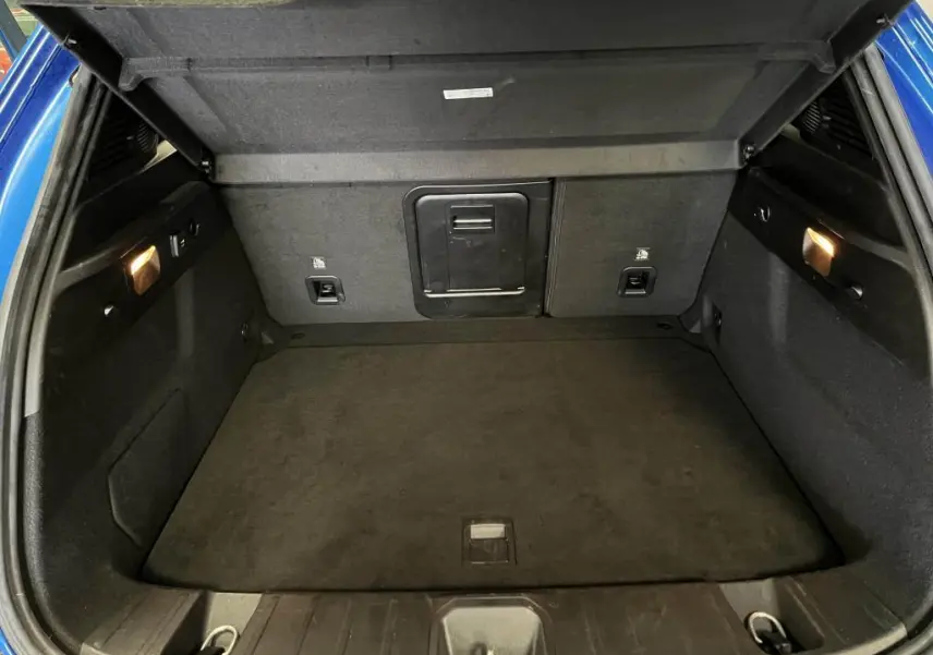 Coffre ouvert de l'Alfa Romeo Tonale bleu, montrant l'espace de chargement et la banquette arrière rabattable.