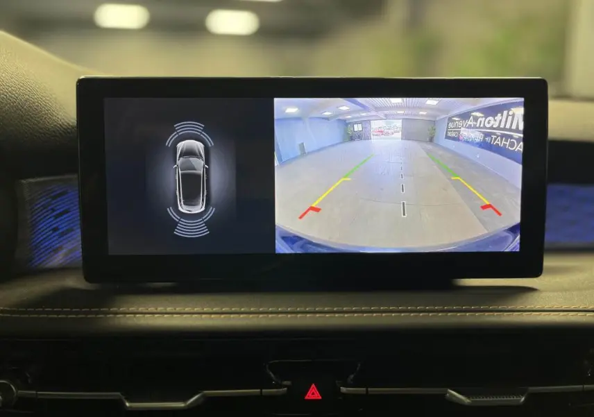 Écran central affichant la caméra de recul et les capteurs de stationnement de l'Alfa Romeo Tonale bleu 2024.