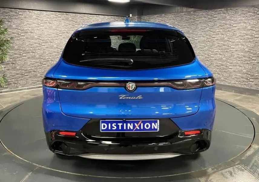 Vue arrière de l'Alfa Romeo Tonale bleu métallisé 2024 avec feux arrière full LED et logo chromé central.