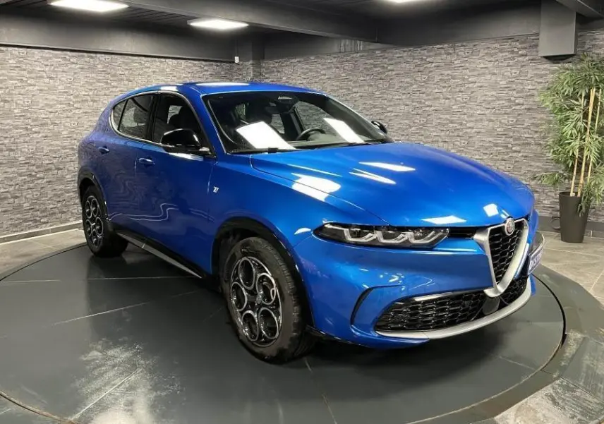 Vue 3/4 avant droit d'un Alfa Romeo Tonale 1.5 mHEV 160 TI bleu métallisé avec jantes alliage et calandre chromée.