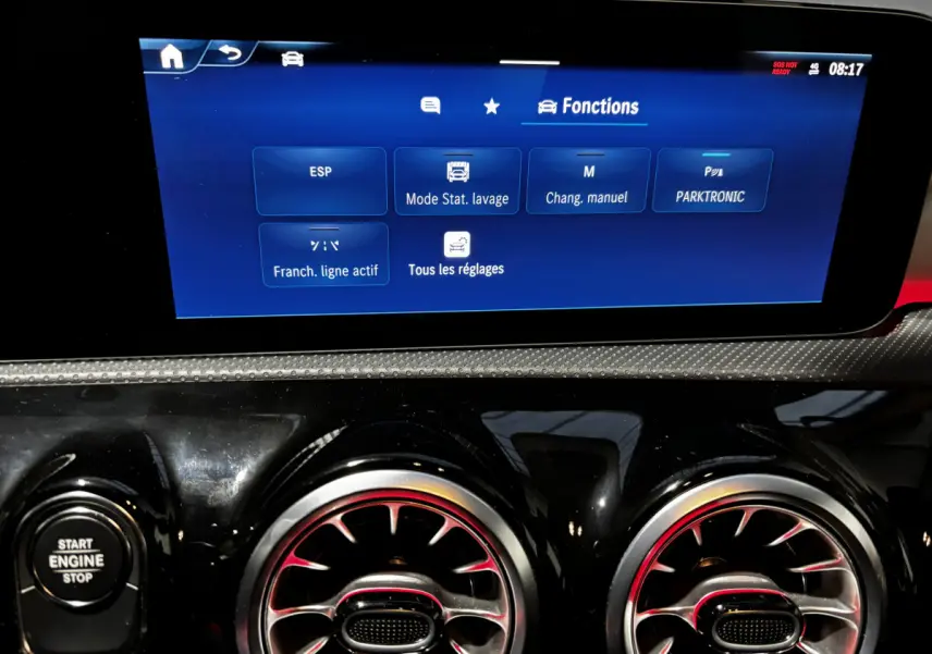 Vue rapprochée du tableau de bord noir brillant de la Mercedes CLA 250 e AMG Line 2023, avec écran tactile affichant les fonctions.