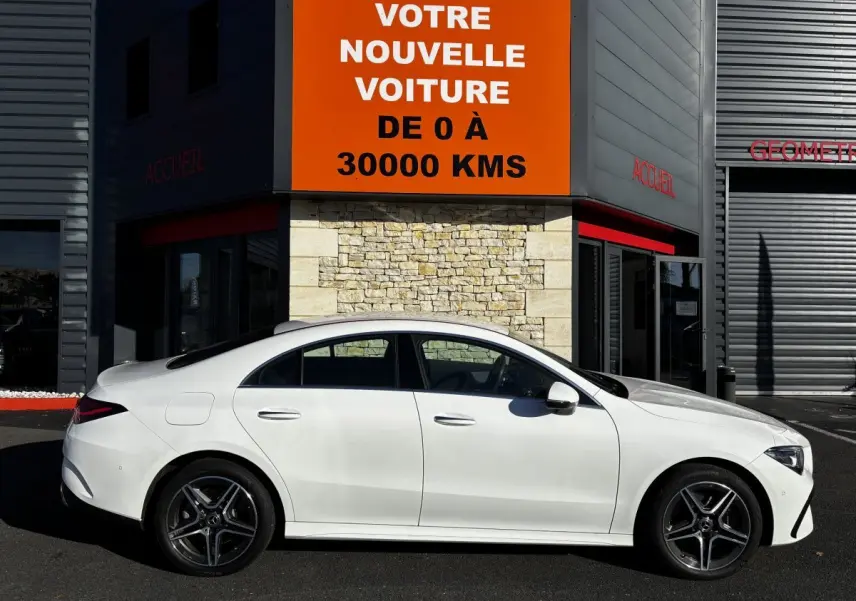 Vue latérale droite d'une Mercedes CLA 250 e AMG Line blanche 2023, avec jantes AMG et silhouette élégante.