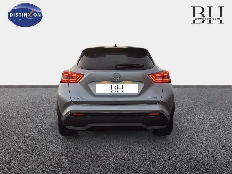 Vue arrière d'un Nissan Juke 1.6 Hybrid 143ch Tekna 2025 en gris perle métallisé avec feux LED allumés.
