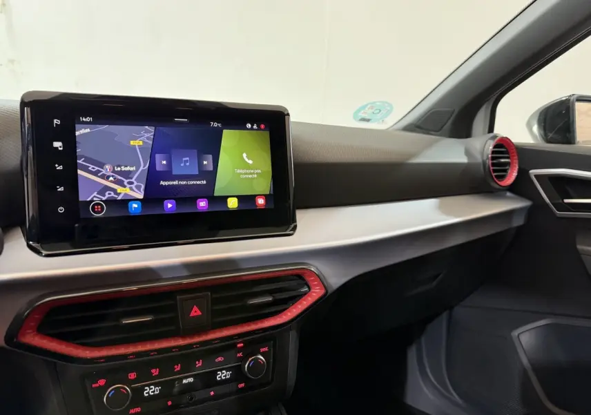 Vue intérieure côté passager du tableau de bord de la SEAT Ibiza 2024 avec écran tactile et aérateurs rouges.