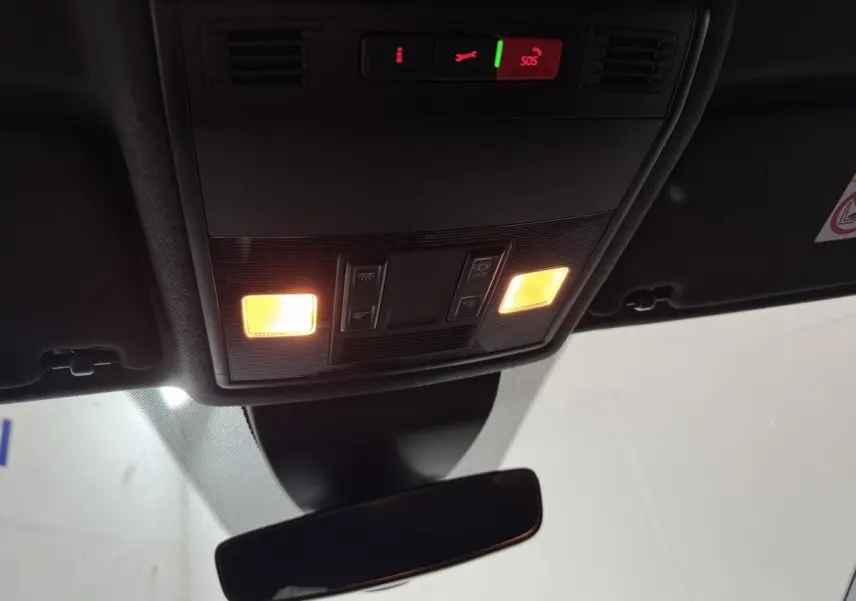 Vue intérieure du plafond avant de la SEAT Ibiza 1.0 TSI 110 FR blanc, avec éclairage et commandes SOS allumées.