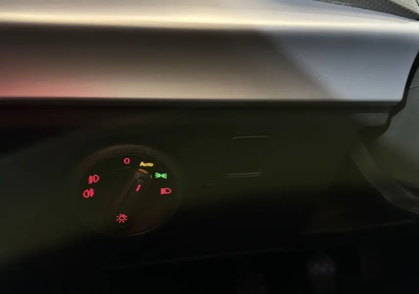Gros plan sur le bouton de commande des phares du tableau de bord d'une SEAT Ibiza blanche, version 2024.