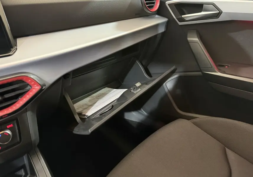 Vue intérieure côté passager du tableau de bord gris et noir avec boîte à gants ouverte de la SEAT Ibiza 1.0 TSI 110 FR blanche 2024.