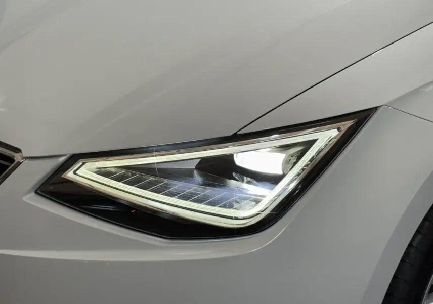 Gros plan sur le phare avant droit LED d'une SEAT Ibiza blanche, soulignant ses lignes anguleuses modernes.