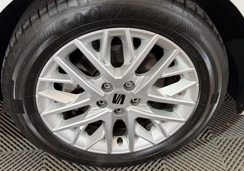 Gros plan sur la jante alliage argentée et pneu Goodyear d’une SEAT Ibiza blanche, vue côté roue arrière.