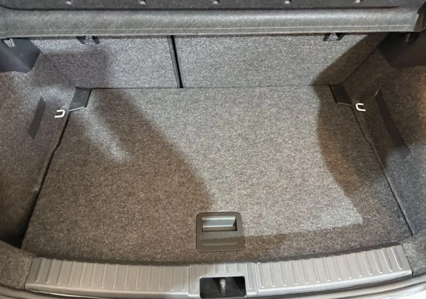 Coffre vide de la SEAT Ibiza 1.0 TSI 110 FR 2024 blanc, vue plongeante sur la surface tapissée et les fixations.