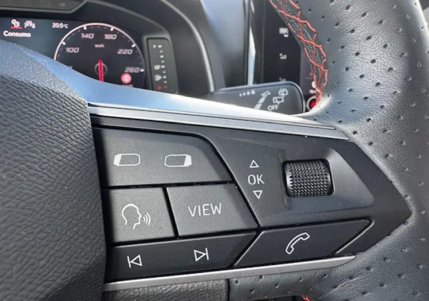 Gros plan sur les commandes du volant perforé avec surpiqûres rouges du SEAT Arona 2024 finition FR.