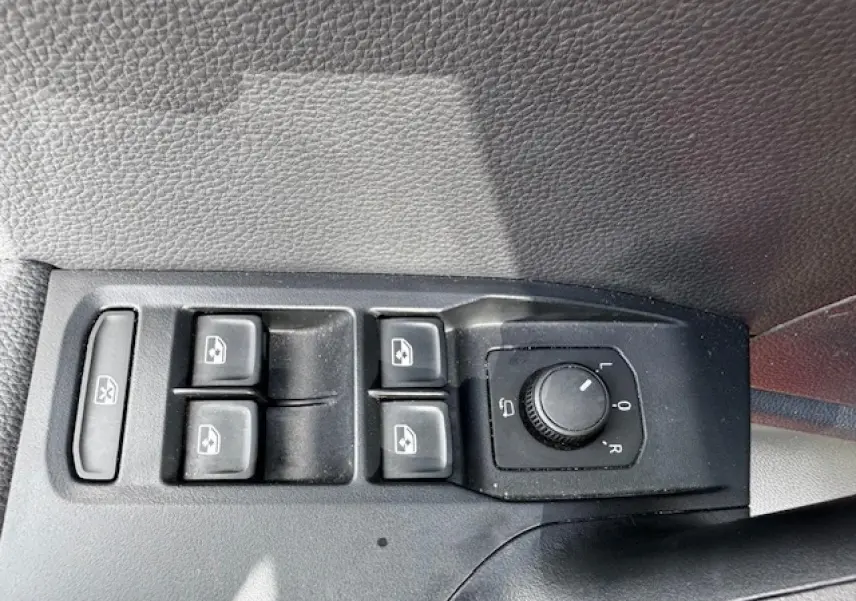 Panneau de commandes des vitres et rétroviseurs côté conducteur d'une SEAT Arona 2024 avec intérieur noir texturé.