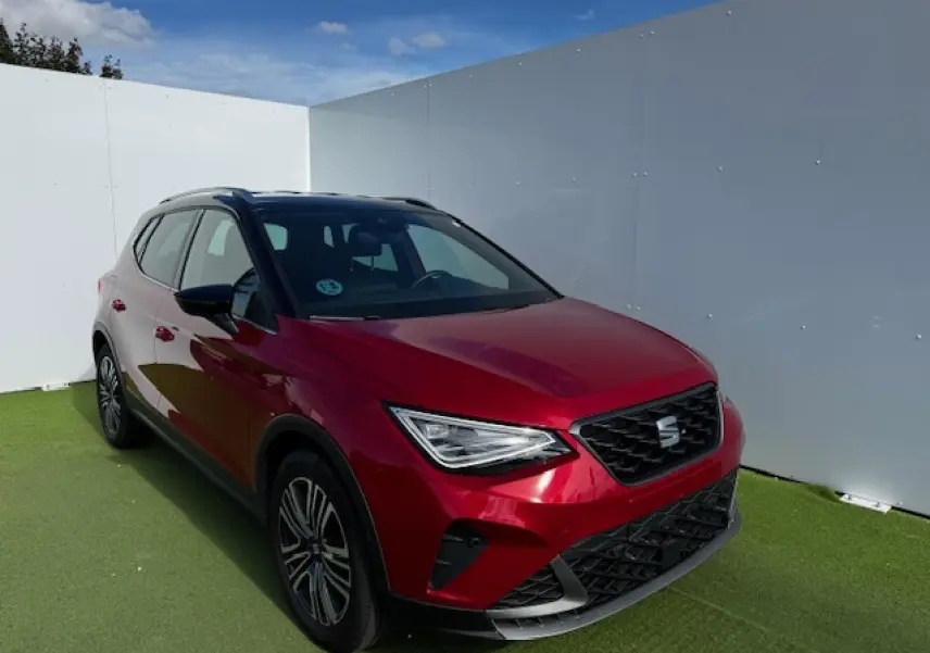 SEAT Arona rouge Désir avec toit noir, vue 3/4 avant droit, calandre FR et jantes alliage 17 pouces.