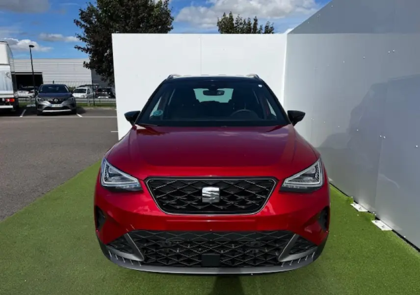 Vue de face d'un SEAT Arona 2024 rouge Désir avec toit noir et calandre spécifique FR gris cosmique.