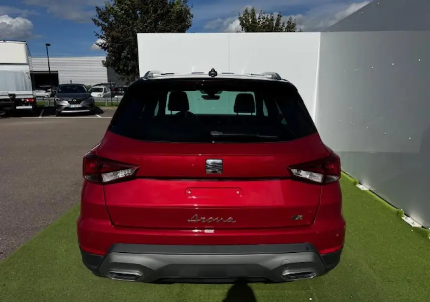 Vue arrière d'un SEAT Arona rouge Désir avec toit noir et double sortie d'échappement intégrée au diffuseur gris.