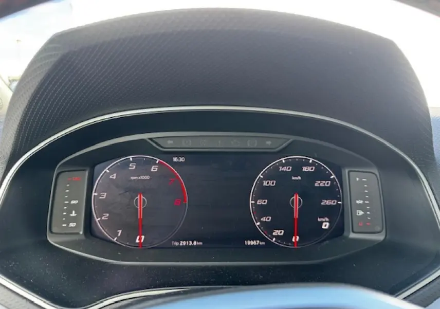 Vue rapprochée du tableau de bord numérique du SEAT Arona 2024, affichant compte-tours et vitesse à l'arrêt.