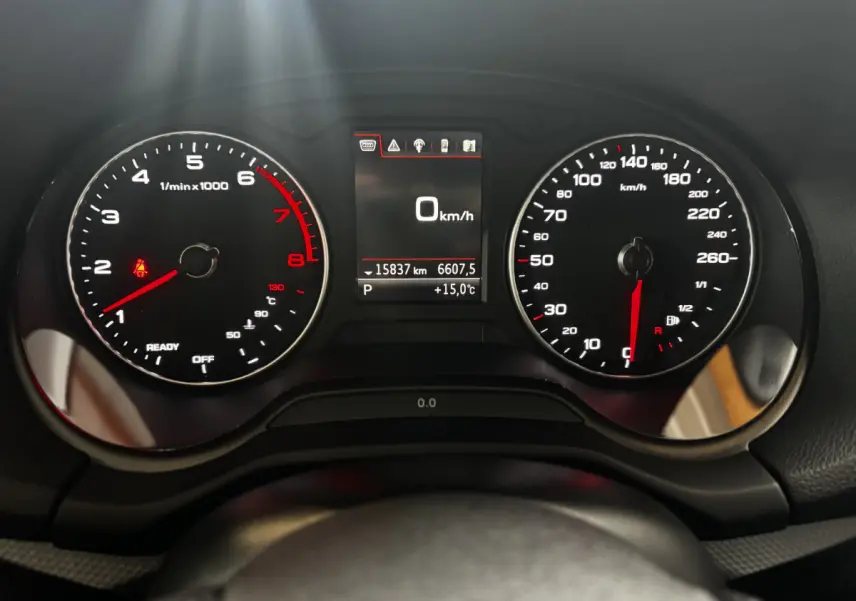 Vue rapprochée du combiné d'instruments noir de l'Audi Q2 35 TFSI 2023, affichant 0 km/h et 15°C.