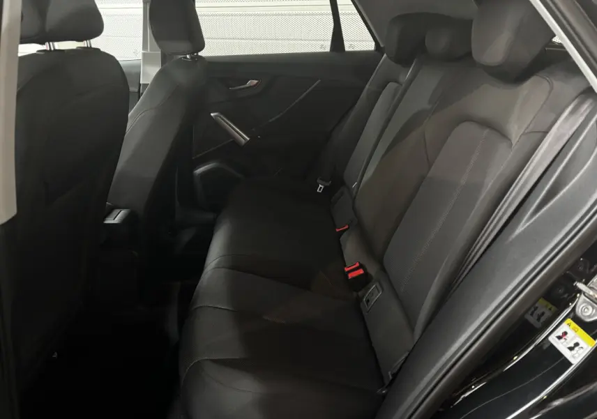 Vue intérieure côté droit des sièges arrière noirs de l'Audi Q2 35 TFSI S Line 2023 avec habillage tissu.