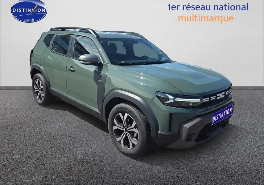 Vue 3/4 avant gauche d'un Dacia Duster 2025 vert kaki avec jantes alu et barres de toit noires.