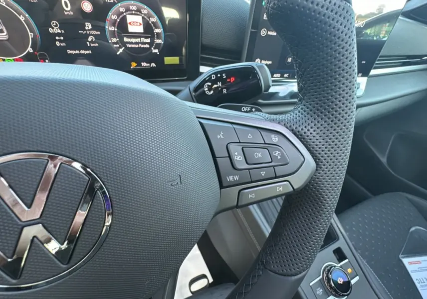 Vue rapprochée du volant cuir perforé noir du Volkswagen T-Roc 2026 avec commandes multifonctions et tableau de bord digital.