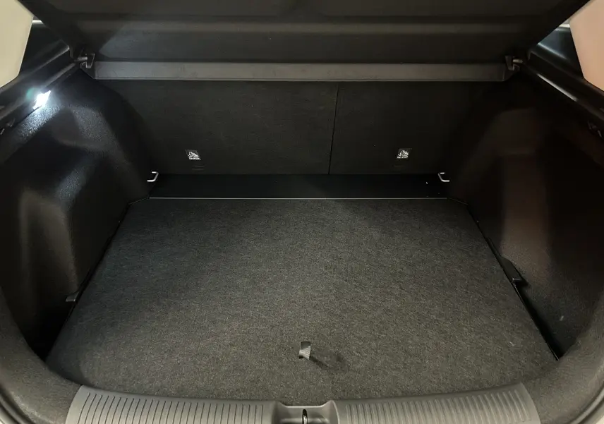 Coffre ouvert vu de l'arrière du MG ZS Hybrid+ 2025, espace de chargement propre et tapis gris foncé.