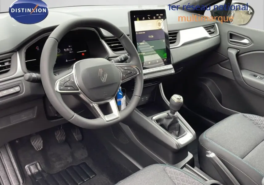 Intérieur avant du Renault Captur 2025 noir étoile métal, volant multifonction et écran tactile vertical au centre.