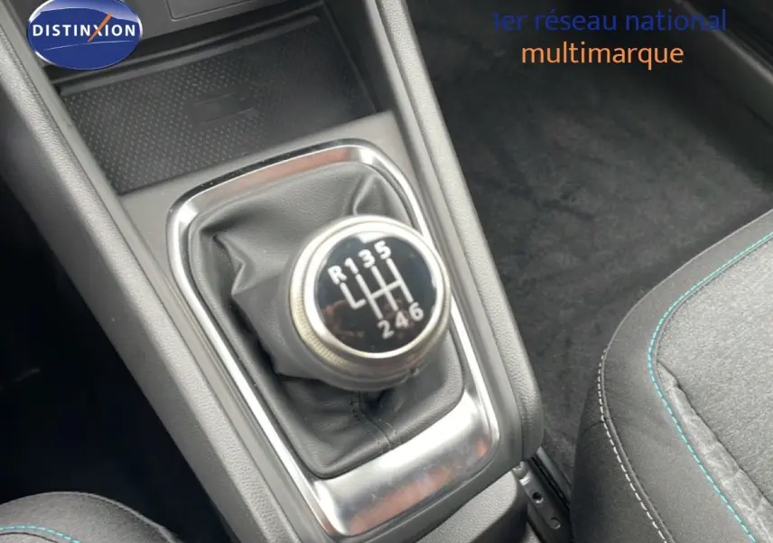 Gros plan sur le levier de vitesses manuel du Renault Captur 2025, intérieur noir avec surpiqûres bleues.