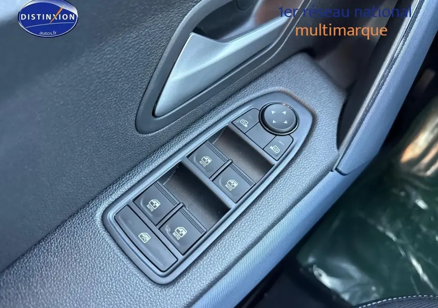 Gros plan sur les commandes des vitres électriques côté conducteur du Dacia Duster gris schiste, avec bouton de réglage des rétroviseurs.