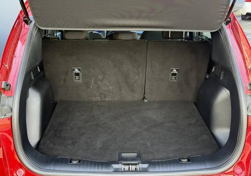 Coffre ouvert vu de l'arrière du Ford Kuga rouge Lucifer 2024, montrant l'espace de chargement vide.