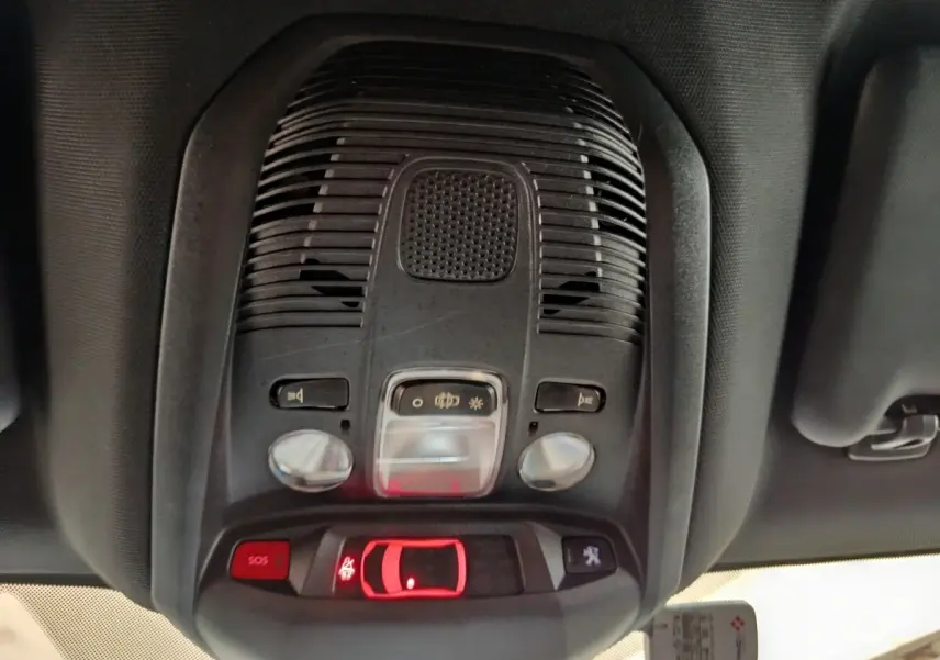 Vue intérieure du plafonnier avant du Peugeot 3008 bleu hybride rechargeable, avec commandes d’éclairage et bouton SOS.