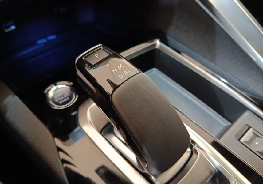 Gros plan sur le levier de vitesses automatique noir et gris du Peugeot 3008 hybride rechargeable, avec bouton start/stop visible.