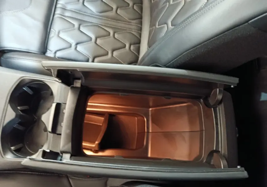Vue plongeante sur le rangement central ouvert et les sièges en cuir noir du Peugeot 3008 hybride rechargeable bleu.