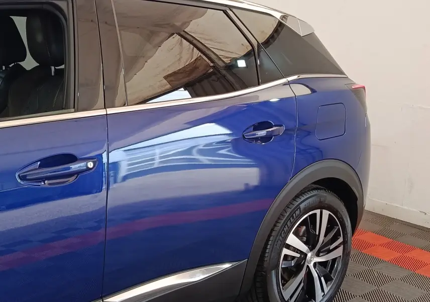 Vue latérale droite sur la porte arrière et la roue arrière d’un Peugeot 3008 bleu hybride rechargeable 2020.