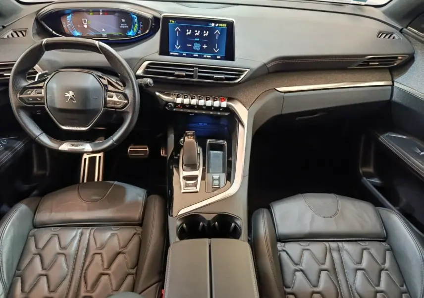 Vue intérieure avant du Peugeot 3008 GT Pack 1.6 Hybrid 225, avec tableau de bord numérique et sièges cuir noirs.