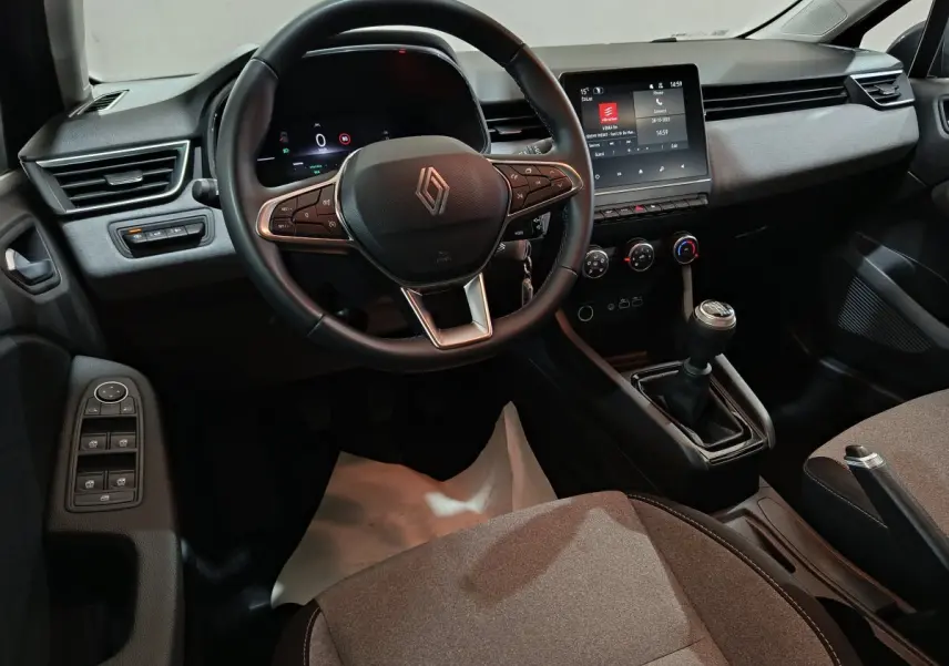 Vue intérieure avant de la Renault Clio noire 2025, volant cuir multifonctions et écran tactile central visible.