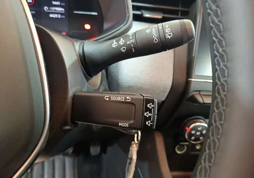 Gros plan sur la commande multifonctions noire à gauche du volant dans l’habitacle d’une Renault Clio noire 2025.