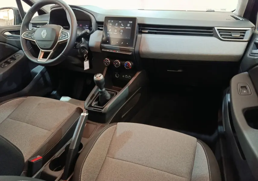 Vue intérieure avant droite de la Renault Clio noire 2025, montrant le volant, la boîte manuelle et l'écran tactile central.